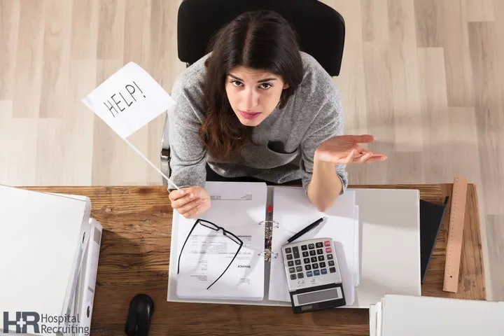 a woman doctor sitting and doing taxes at her desk