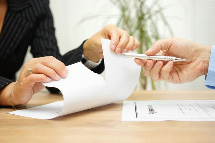 A woman tears up an offer for employment