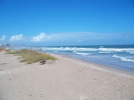 Beach at Fort Pierce Inlet State Park with hotels in the distance
