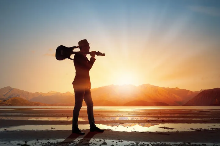 A physician "rock star" takes a stroll on the beach with his guitar. The article discusses what is meant by the term "rock star" when it is applied to physicians and how doctors can become that type of physician