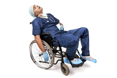 An exhausted physician sleeping in a wheelchair