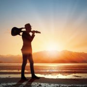 A physician "rock star" takes a stroll on the beach with his guitar. The article discusses what is meant by the term "rock star" when it is applied to physicians and how doctors can become that type of physician