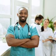 A young male nurse is smiling on the job