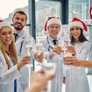 Doctors in santa hats clink champagne